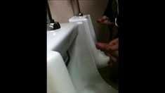 two slim dicks getting wanked at the urinals