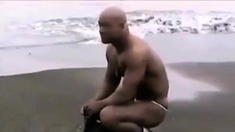 Asian bodybuilder barely covered at the beach